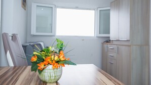 A dining area with a table, chairs, a vase of flowers, and a window. - Small robinson house with pool (Vinišce)