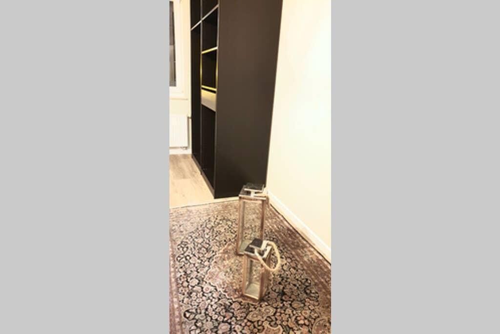 Ein Flur mit einem gemusterten Teppich, einer schwarzen Wand und einer Tür zu einem Zimmer.