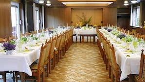 A long dining table with chairs, white tablecloths, and floral centerpieces. - Untere Kapfenhardter Mühle (Schoemberg)