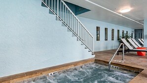 Een zwembad met een trap naar een balkon.