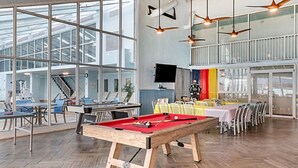 Ruime binnenruimte met pooltafel, zwembad en zithoek.