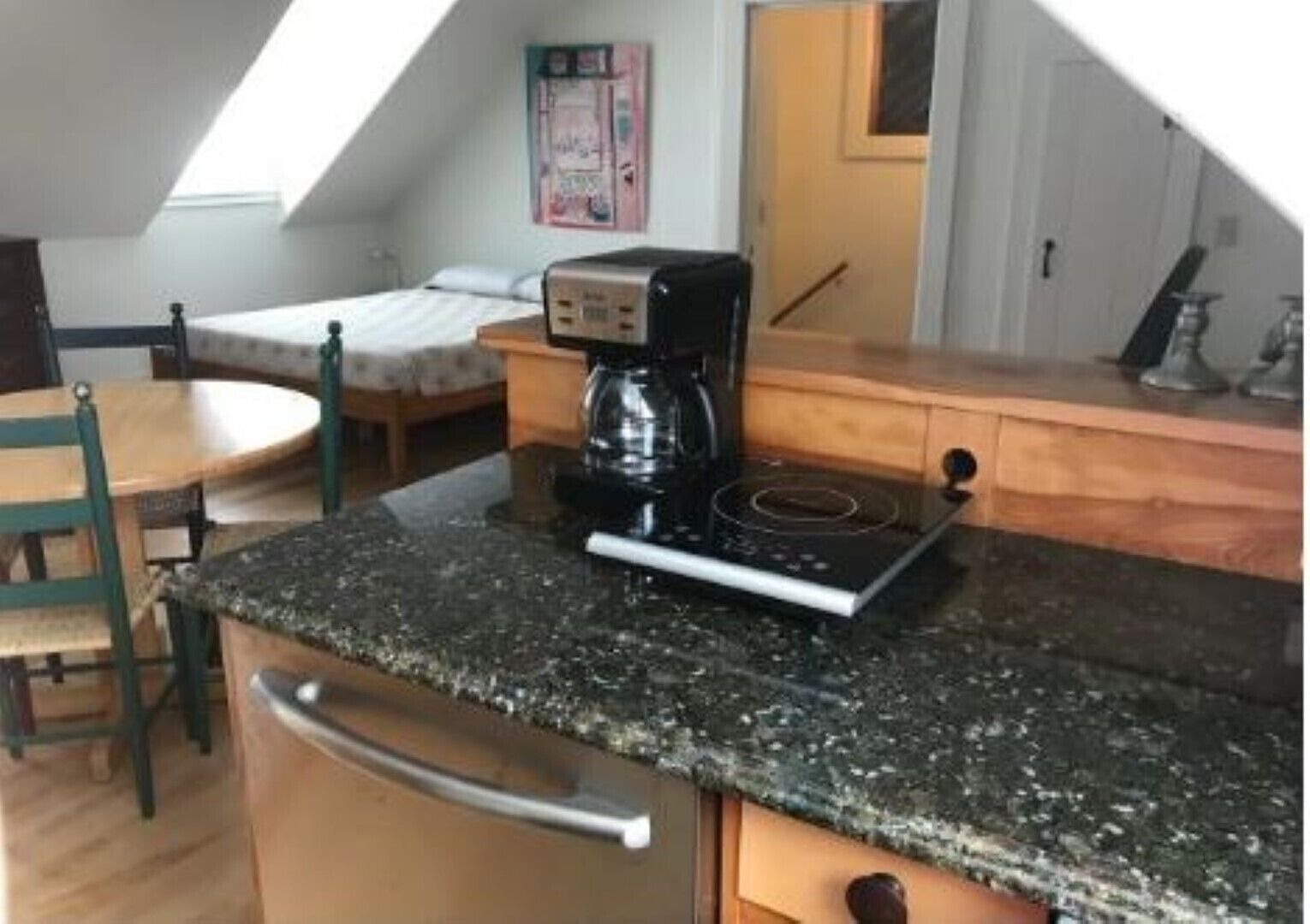 A small kitchenette with a coffee maker, a stove, and a sink.