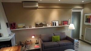 A modern living room with a grey sofa, a coffee table, and a bookshelf. - Luxury 10thfloor Penthouse Stunning View Over Rome. Big Terrace (Roma)