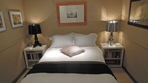 A neatly arranged bedroom with a bed, two bedside tables, a lamp, and a framed picture on the wall. - Luxury 10thfloor Penthouse Stunning View Over Rome. Big Terrace (Roma)