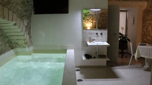 Une salle de bain avec une baignoire, un lavabo et un miroir.
