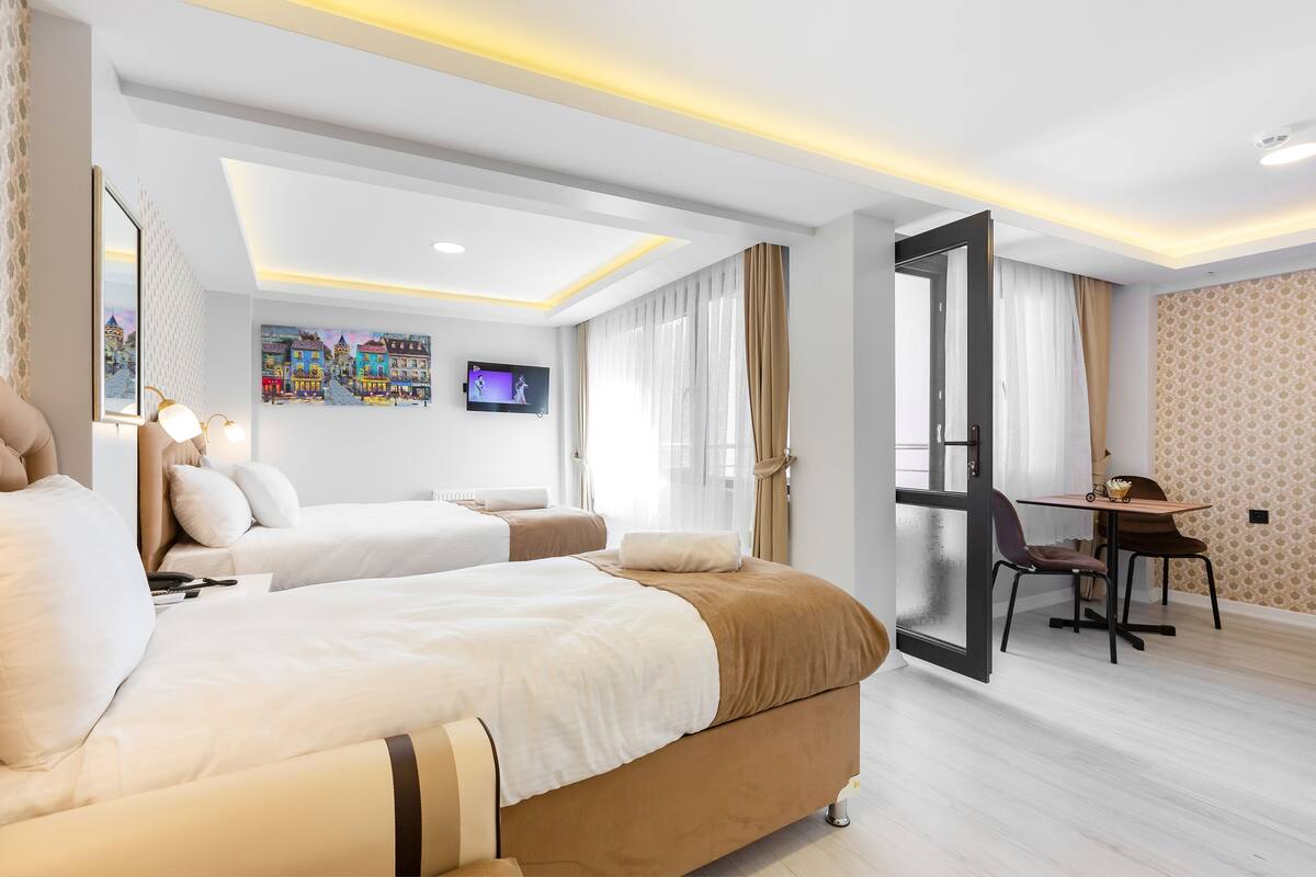 Una habitación de hotel moderna con dos camas, un escritorio y un televisor.