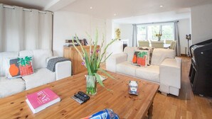Una sala de estar moderna con una mesa de centro de madera, sofás blancos y un piano.