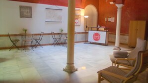 A lobby with a reception desk, seating area, and a 'Happy Home' sign. - San Isidoro Hostel Sevilla (Seville)