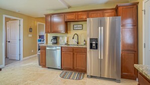 A kitchen with wooden cabinets, stainless steel appliances, and a coffee maker. - 2bd,1ba Remodeled Home w/large yard and Corn Hole Game (Los Ranchos De Albuquerque)