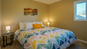 A bedroom with a bed, two bedside lamps, a ceiling fan, and a window. - 2bd,1ba Remodeled Home w/large yard and Corn Hole Game (Los Ranchos De Albuquerque)