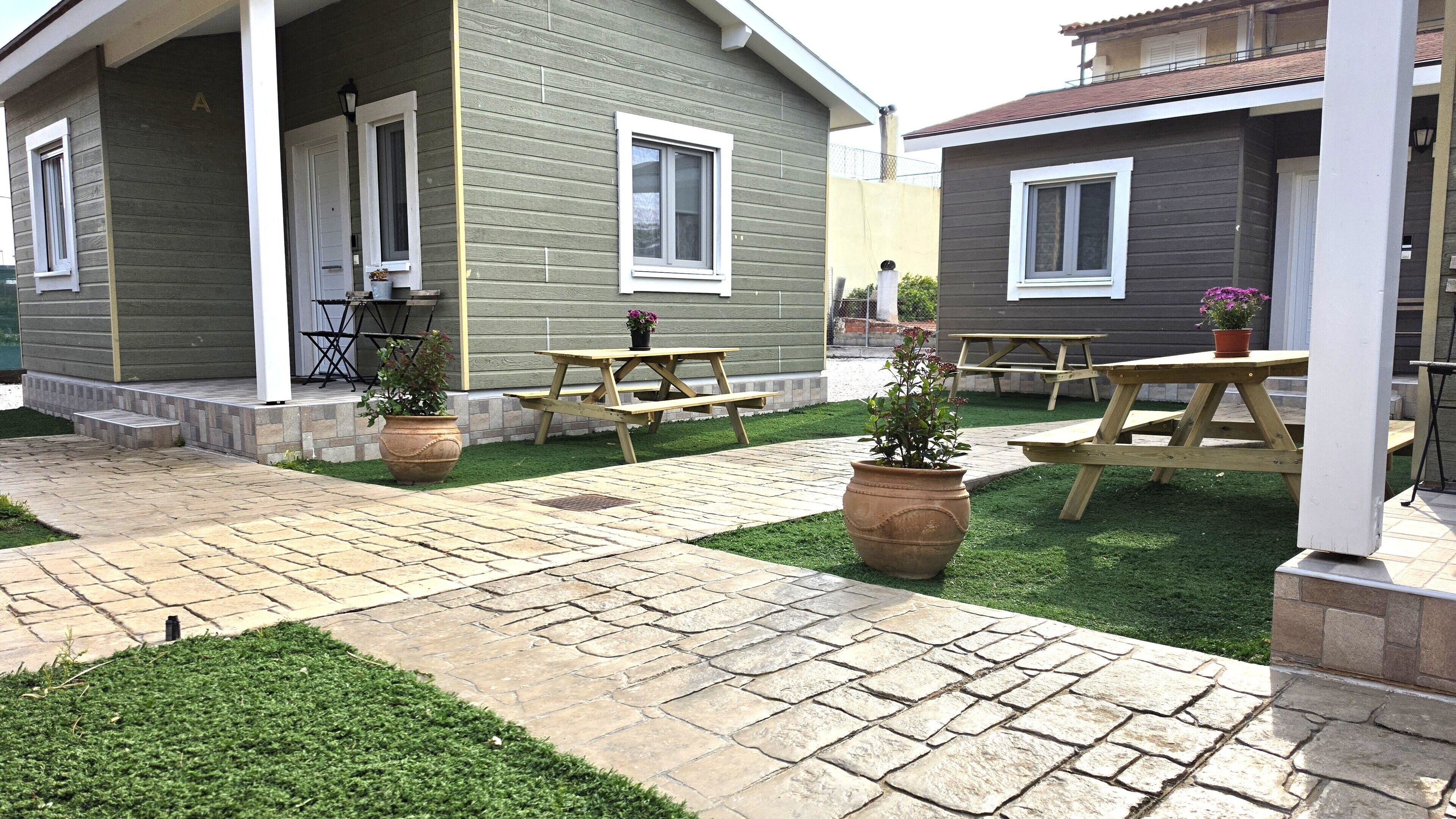 A courtyard with outdoor seating, a paved walkway, and a well-maintained lawn.
