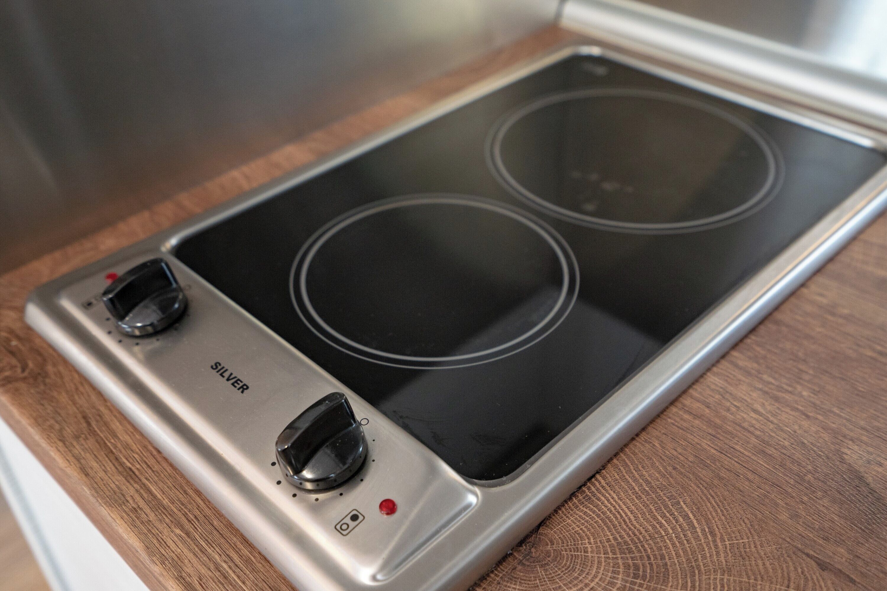 A stainless steel induction cooktop with two burners and a control panel.