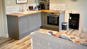 A compact kitchen with grey cabinets, a wooden countertop, and a built-in oven. - The Georgian Loft Apartment Central Bath (Bath)