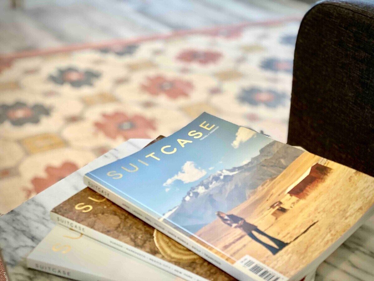 Una pila di libri intitolati 'Valigia' su un tavolo con una tappeto decorato.