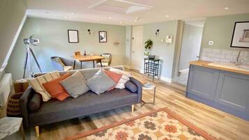 A cozy living room with a sofa, coffee table, and a dining area with a table and chairs.