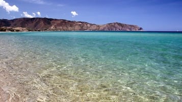 Playa en los alrededores, playa de arena blanca, camastros y sombrillas 