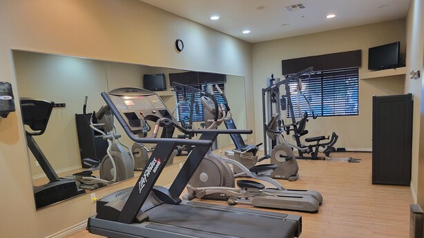 A gym with treadmills, elliptical machines, and a mirrored wall. - Cotulla Whitten Inn (Cotulla)