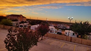 A parking lot with RVs and a building in the background. - Cotulla Whitten Inn (Cotulla)