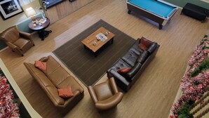 A spacious lobby with a pool table, leather sofas, a reception desk, and a television. - Cotulla Whitten Inn (Cotulla)