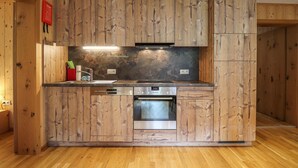 Een keuken met houten kastjes, een roestvrijstalen oven en een ingebouwde vaatwasser.