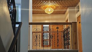 A multi-level interior with a staircase, a decorative ceiling, and patterned flooring. - BigBlue Hostel Surf & Coworking (Taghazout)