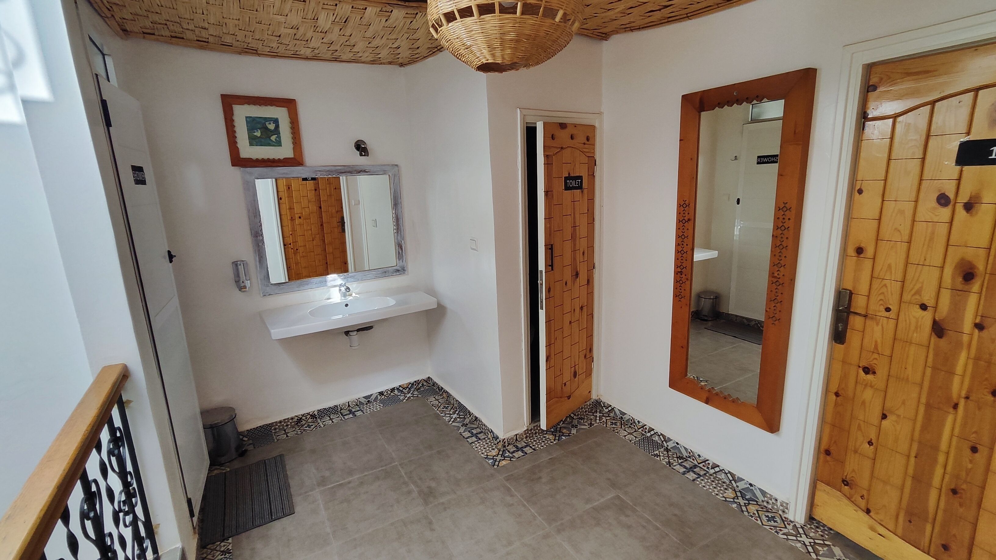 Ein Badezimmer mit Waschbecken, Spiegel und Holztüren.