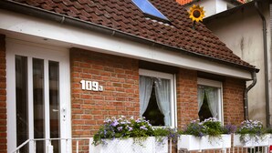 Un bâtiment en briques avec une porte et des fenêtres blanches, le numéro 109 étant visible sur le mur.