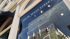 A building with a sign reading "Clarke Main Street" and "Compass Creative Suites."