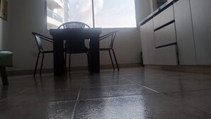 Un comedor con una mesa, sillas, una ventana y una cocina con armarios.