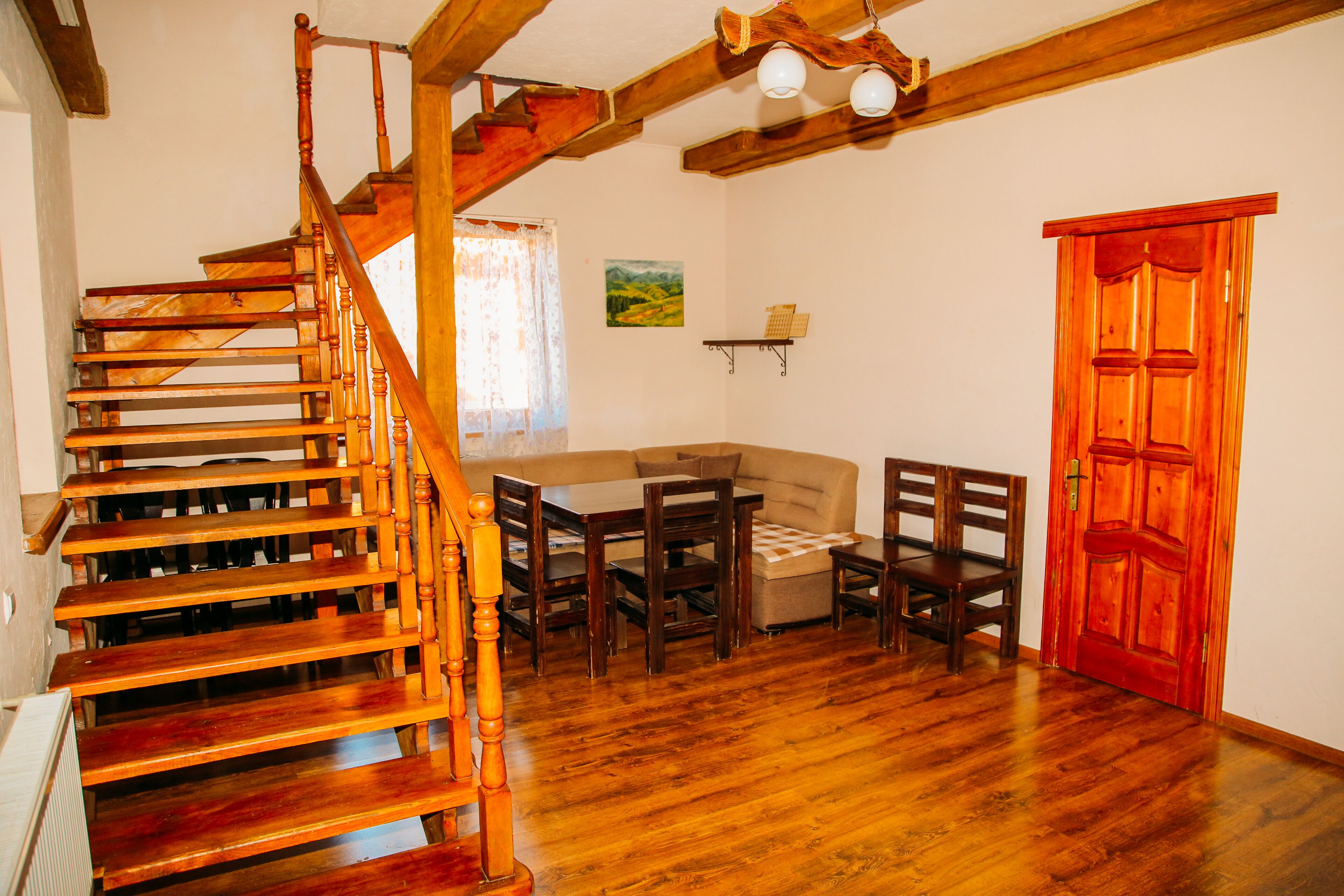 A wooden staircase leading to a loft bedroom with a view of the countryside.