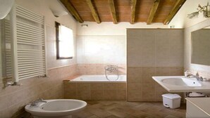 Ein Badezimmer mit einer Badewanne, zwei Waschbecken und einer Toilette.