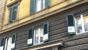 Un edificio de estilo arquitectónico clásico, con una entrada central y un arco decorativo, y un cartel que indica el nombre NOTAIO.