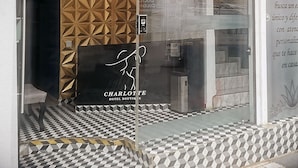 A hotel boutique with a geometric patterned wall, a chandelier, and a checkered floor.