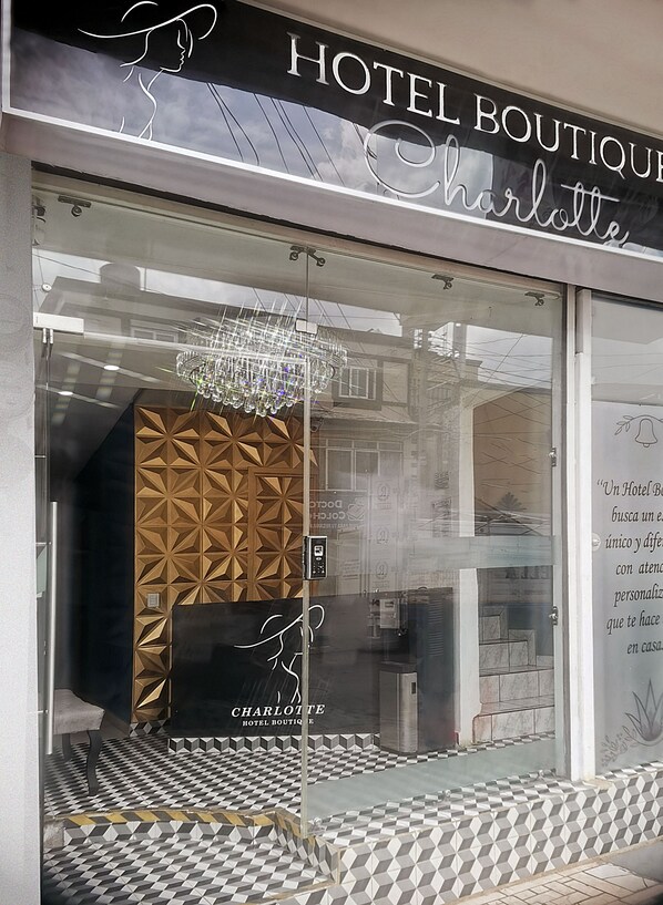 A hotel boutique with a geometric patterned wall, a chandelier, and a checkered floor. - Hotel Boutique Charlotte (Arandas)