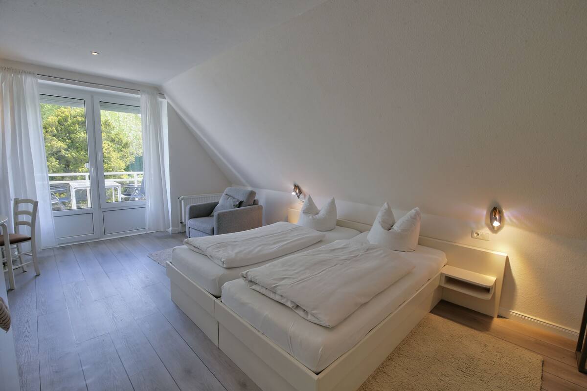 Une chambre avec un grand lit, un bureau et une chaise.