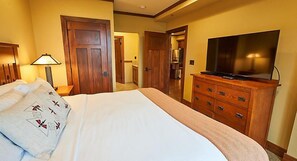 A hotel room with a bed, a dresser, a television, and a lamp. - Luxurious units at The Cliffs at Long Creek! (Ridgedale)