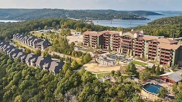A resort with multiple buildings, a swimming pool, and a bridge in the background.