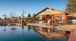 A poolside area with a building, lounge chairs, and a cross. - Luxurious units at The Cliffs at Long Creek! (Ridgedale)