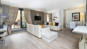 A modern living room with a sofa, a coffee table, and a dining area with a table and chairs. - Elegant Two bedroom in the heart of Kensington (London)