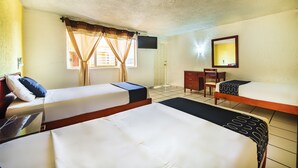 A hotel room with two beds, a desk, a chair, a TV, and a mirror. - Capital O Colón,  Ciudad Guzmán Jalisco (Zapotlán el Grande)