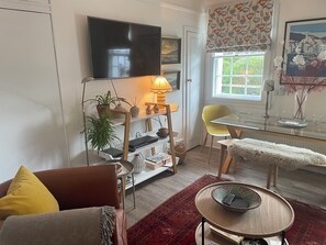 Relax in this inviting living room with a flat-screen TV, comfortable sofa, and stylish seating area.
