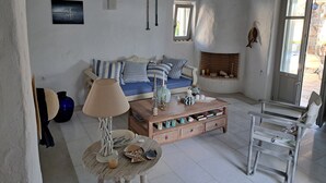 A cozy living room with a sofa, a coffee table, a lamp, and a fireplace.