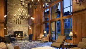 Un hall espacioso con chimenea de piedra, asientos cómodos y ventanas amplias.