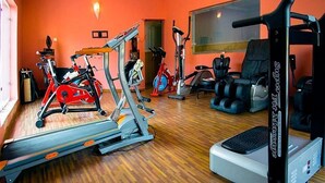 A gym with cardio machines, weightlifting equipment, and a seating area. - Bleu Ivy Hotel & Suites (Lagos)