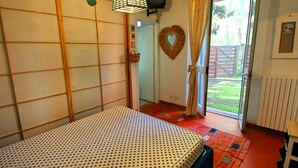 A room with a bed, a television, a heart-shaped decoration, and a view of the outside.
