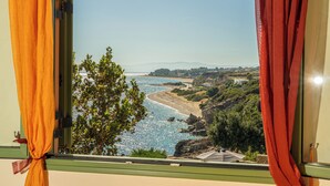 A window view of a coastal landscape with a clear sky, a beach, and greenery. - Three-Bedroom Seafront Villa, Brio Complex | Private Pool & Jetty | Sleeps 6–8 (Kefalonia Island)