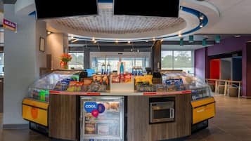 A self-service beverage kiosk with a refrigerated display and a digital screen.