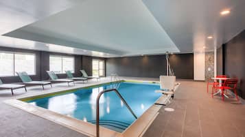 Una piscina techada, sillones reclinables de piscina