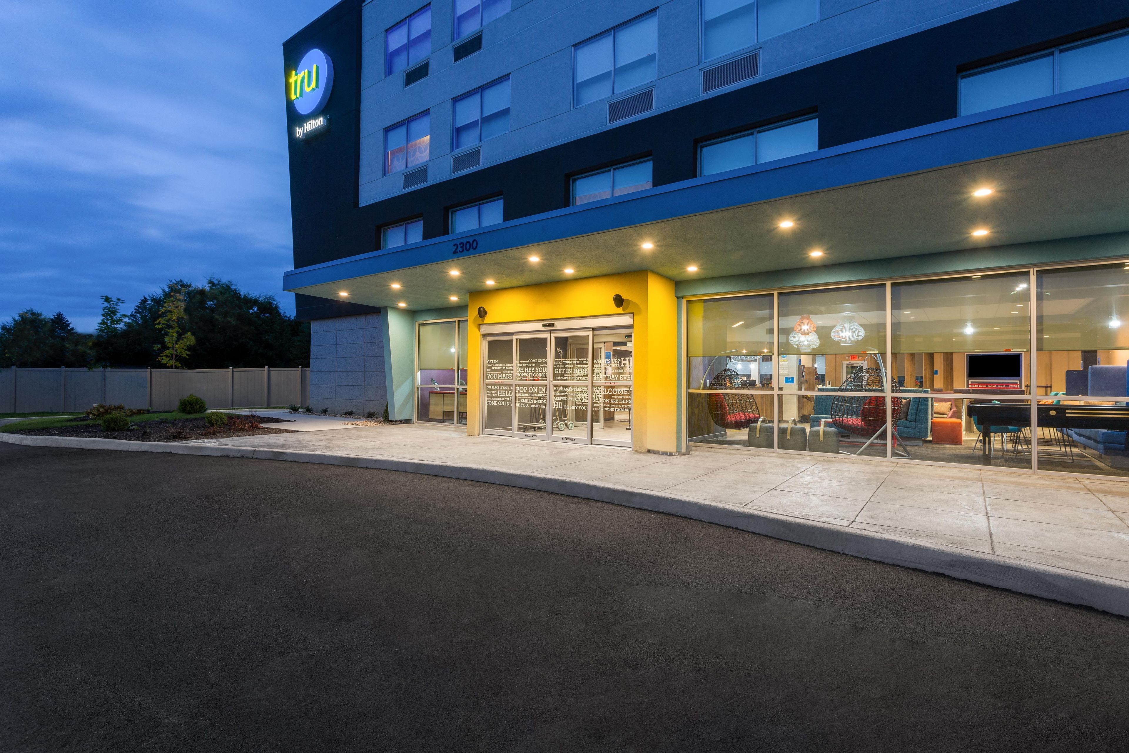 A hotel with a modern facade, a visible entrance, and a clear sky.