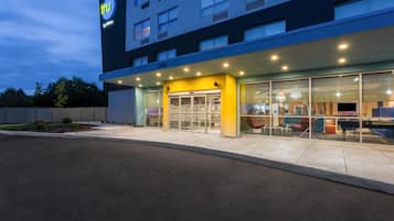 A hotel with a modern facade, a visible entrance, and a clear sky.
